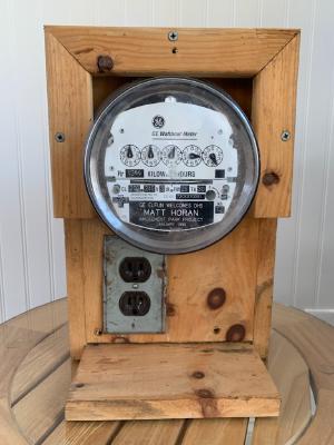 Electric meter with outlet